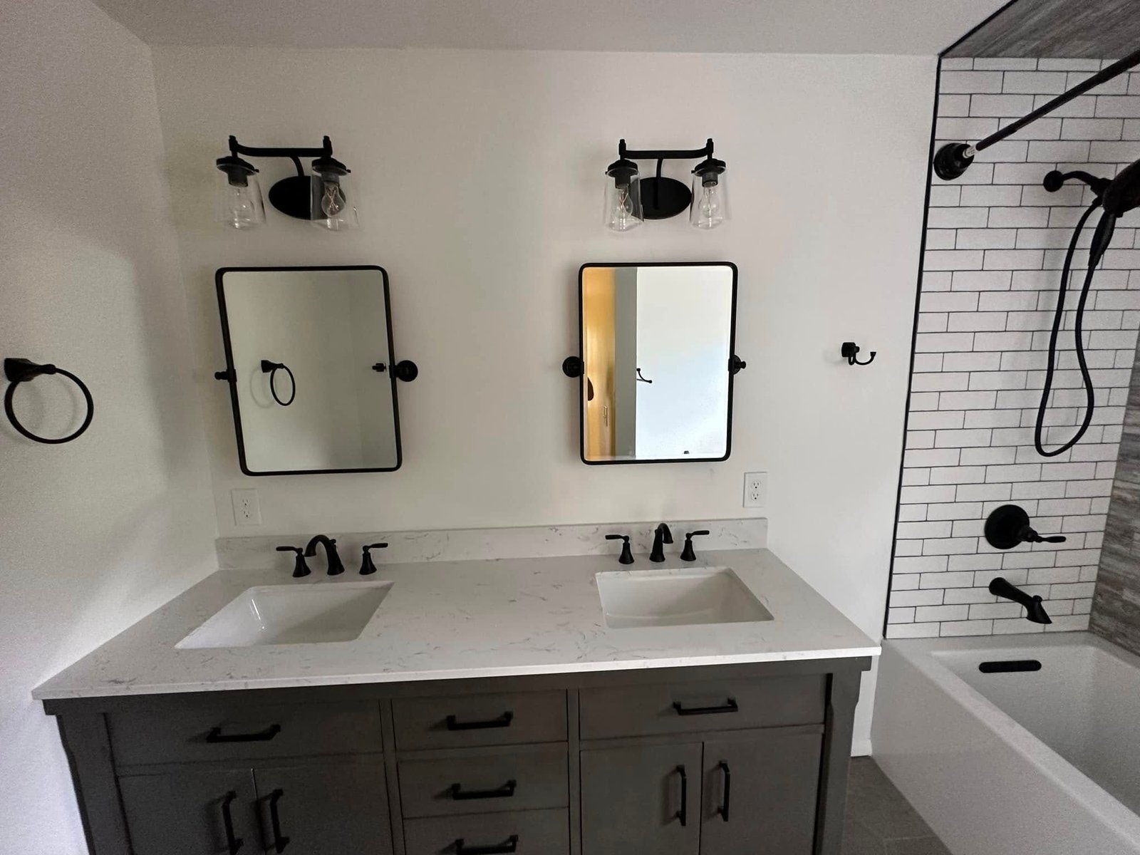 Double vanity with charcoal cabinets and black fixtures